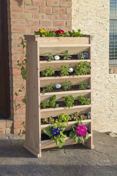 a wooden planter filled with plants next to a brick building