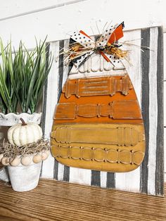 a wooden sign that has been decorated with pumpkins and other fall decorations on it