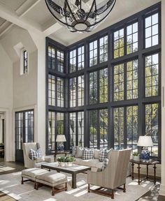 a living room filled with furniture and large windows