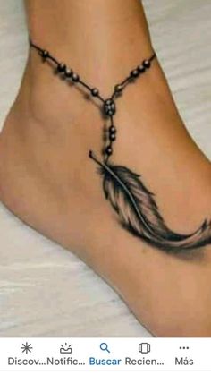 a woman's foot with a black and white feather tattoo on the side of her leg