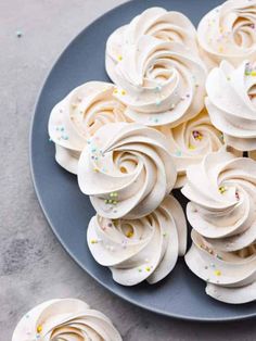 cupcakes with white frosting and sprinkles on a blue plate