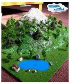 a model of a small lake surrounded by trees and rocks with a sign in the background