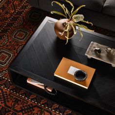 a coffee table with a laptop, phone and other items sitting on top of it