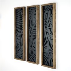 two wooden frames with carved designs on them hanging on the wall next to each other