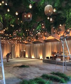 a room that has some lights hanging from the ceiling and plants growing on the walls