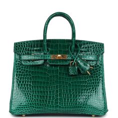 This Birkin is in Vert Emeraude shiny porosus crocodile with gold hardware and has tonal stitching, front flap, two straps with center toggle closure, clochette with lock and two keys, and double rolled handles.The interior is lined with Vert Emeraude chevre and has one zip pocket with an Hermes engraved zipper pull and an open pocket on the opposite side.Collection: COrigin: FranceCondition: Never worn (plastic on hardware)Accompanied by: Hermes box, Hermes dustbag, clochette, lock, two keys, clochette, clochette dustbag, felt, carebook, CITES, rainhatMeasurements: 10" width x 7.5" height x 4.75" depth; 2.75" handle drop Hermes Birkin 25, Hermes Box, Birkin 25, Madison Avenue, Hermes Birkin, Gold Hardware, Zip Pockets, Dust Bag, Emerald