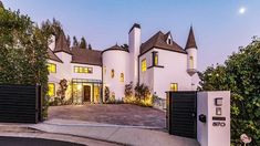 a large white house with lots of windows on it's front gate and driveway