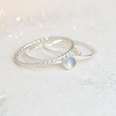 Moonstone is one of the birthstones representative of a June birthday. This stone is valued for the belief that it holds centering, calming and healing properties. It's been used as a gift for lovers and a talisman for travelers. This 4 mm rainbow moonstone is set in sterling silver. Completing your minimalist and dainty stacking set are a sterling silver twist ring and a hammered band.{DETAILS}:* 1.3 mm sterling silver band* 4 mm conflict-free moonstone►Simple and perfect, our single moonstone Make Up Gold, Birthstone Stacking Rings, Silver Drop Necklace, Rings Gemstone, June Birthday, Sterling Silver Stacking Rings, Hammered Band, Stacking Ring Set, Silver Stacking Rings