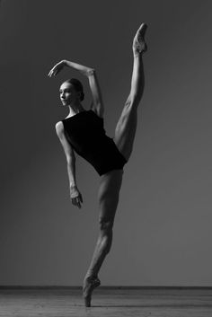 a woman in black leotard doing a dance pose with her legs spread out