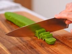 a person is cutting up some food on a wooden board