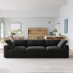 a black couch sitting in the middle of a living room next to a wooden table