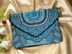 The Turquoise Blue Clutch. Meticulously crafted in India, this stunning work of art boasts delicate beads and sequins hand-stitched onto top-quality Fabric creating an intricate and beautiful design. Ideal for special occasions like parties or formal events, this spacious clutch effortlessly holds essentials while maintaining a compact and stylish profile. Specifications and Dimensions: Main Compartment Front: Embellished  Back: Plain Black Fabric  Long Detachable Metallic Silver Chain Sling (Ap Formal Purse, Blue Clutch Bag, Fabric Clutch, Bohemian Fabric, Beaded Clutch Bag, Blue Clutch, Bohemian Bags, Handbag For Women, Handmade Gifts For Her