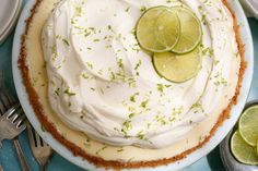 there is a pie with limes on it and two forks next to the pie