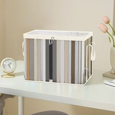 a white desk with a clock and flowers on it