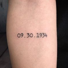 a person with a small tattoo on their arm that reads 90, 30, 1933