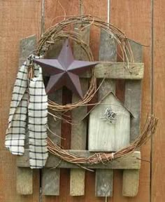 a wooden fence with a star and birdhouse hanging on it's side wall