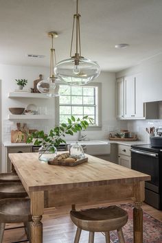 a kitchen with a wooden table surrounded by stools