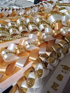 gold and white ribbons are stacked on top of each other