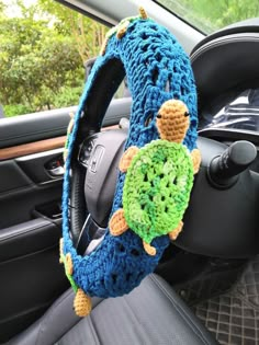 a steering wheel cover with a crocheted turtle on it's center piece