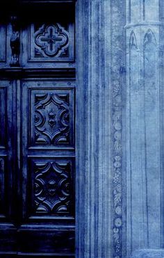 an old door with ornate carvings on the outside and inside, in blue hues