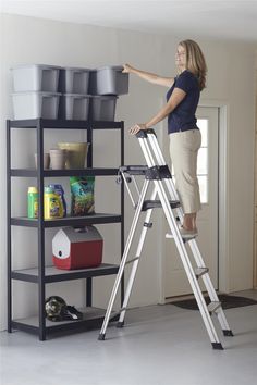 a woman standing on a ladder next to a shelf