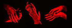 three hands reaching out to each other with red light in the dark above them and on black background