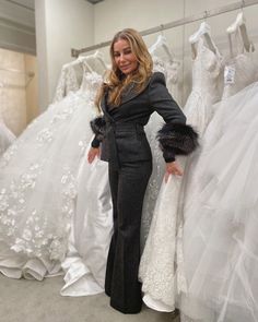 a woman standing in front of wedding dresses