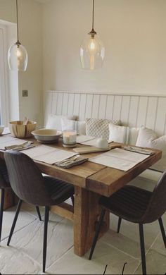 a dining room table with chairs and plates on it