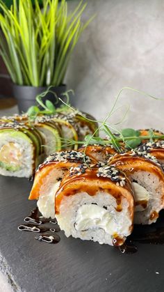 sushi rolls with sauce drizzled on them and garnished with sesame seeds