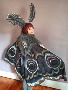 a woman wearing a butterfly costume with feathers on her head and wings attached to her shoulders