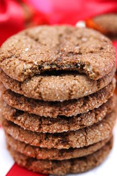 a stack of cookies sitting on top of a white plate next to a red ribbon