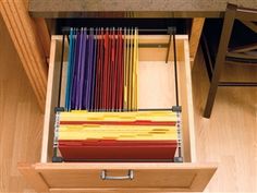 an open drawer with many colored papers in it