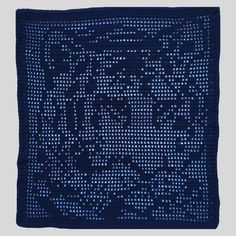 a blue knitted square with an image of a lion on it's face