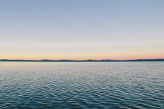 a body of water with mountains in the distance