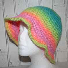 a white mannequin head wearing a multicolored crocheted hat