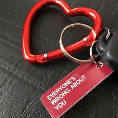 a red heart shaped keychain sitting on top of a table