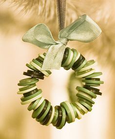 a green wreath ornament hanging from a christmas tree with a bow on it