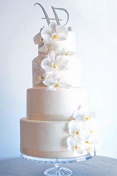 a wedding cake with white flowers and the number twenty on it's top tier