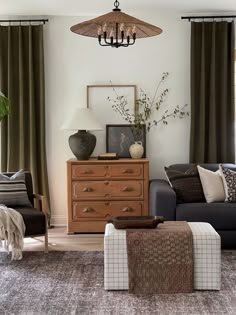 a living room filled with furniture and a chandelier hanging over the top of it