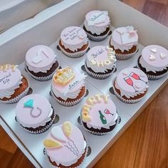 twelve cupcakes are arranged in a box on the wooden floor, one is for sale