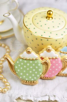 three teapots with polka dots on them are next to a cup and saucer