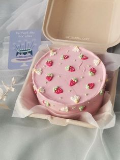 a pink cake in a box on a table