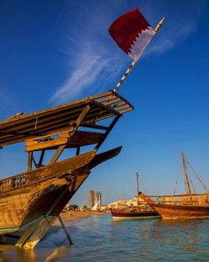 two wooden boats in the water with one boat sticking out of it's side