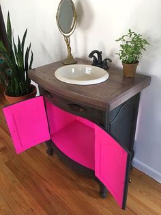 a bathroom with a sink, mirror and potted plants on the floor in front of it