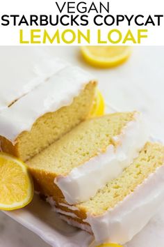 a loaf of lemon cake with white frosting and sliced lemons on the side