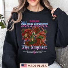 a woman wearing a black sweatshirt with an image of a demon on it