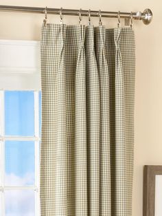 a window with a curtain rod and checkered curtains hanging on the side of it