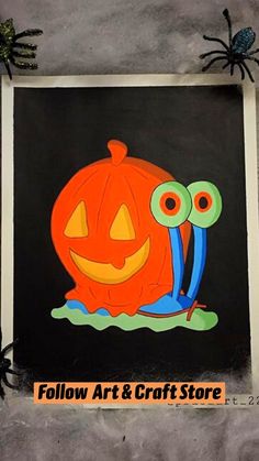 an orange pumpkin with googly eyes sitting on top of a black background next to a spider