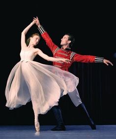 a man and woman in ballet clothes are dancing