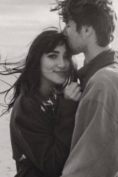 black and white photograph of two people embracing each other with long hair blowing in the wind